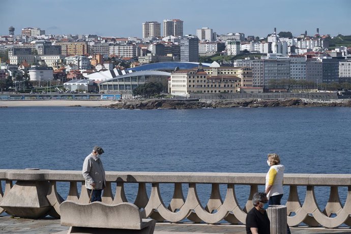 Archivo - Dos personas pasean por el paseo marítimo de A Coruña (Galicia), con el estadio de Riazor de fondo, en el segundo día en que el Gobierno permite salir a hacer deporte de forma individual y pasear con otra persona con la que se conviva, a determi