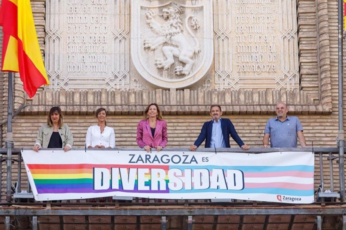 Momento de la colocación de la pancarta 'Zaragoza es diversidad' en el balcón del Ayuntamiento de Zaragoza.