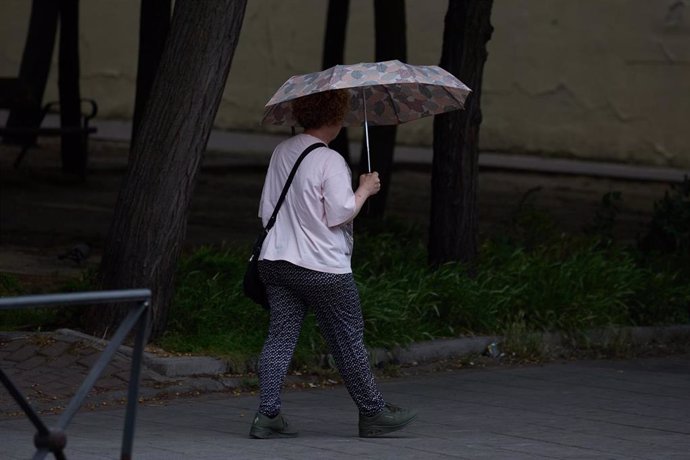 Una mujer se protege de la lluvia con un paraguas, a 8 de junio de 2024, en Madrid (España). 