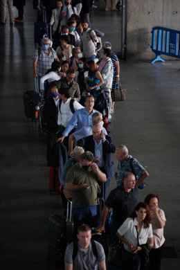 Archivo - Varias personas esperan la cola de los taxis en la terminal de un aeropuerto.