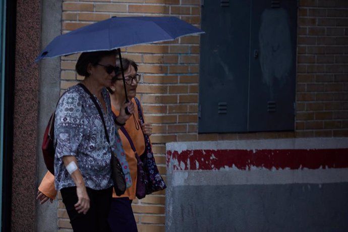Dos mujeres se protegen de la lluvia con un paraguas
