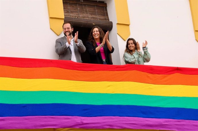 La consejera de Inclusión Social, Juventud, Familias e Igualdad, Loles López, en el Ayuntamiento de Beas (Huelva), que ha desplegado una bandera, de unos nueve metros, confeccionada por mujeres de la localidad.