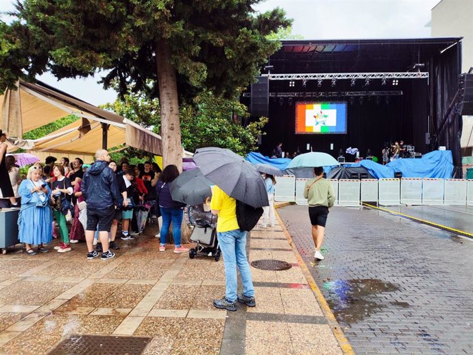 Paseo de Roma en Mérida, donde los asistentes al Día del Orgullo se protegen de la lluvia junto al escenario antes de las actuaciones.