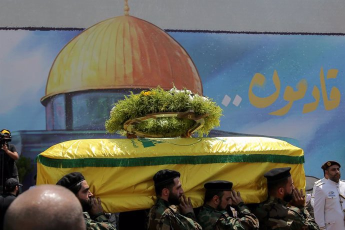 June 12, 2024, Beirut, Beirut, Lebanon: Pro-Iranian Hezbollah militants carry the coffin of Taleb Abdallah, a senior Hezbollah commander, who was assassinated in an overnight Israeli air strike in south Lebanon, in front of a huge painting of Jerusalem al