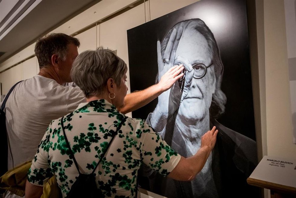 Dos personas tocan el retrato en relieve de Luis Ediuardo Aute, realizado por el fotógrafo Juan Torre, en la muesta "Iguales ante la cámara" en el Museo Tiflológico de la ONCE