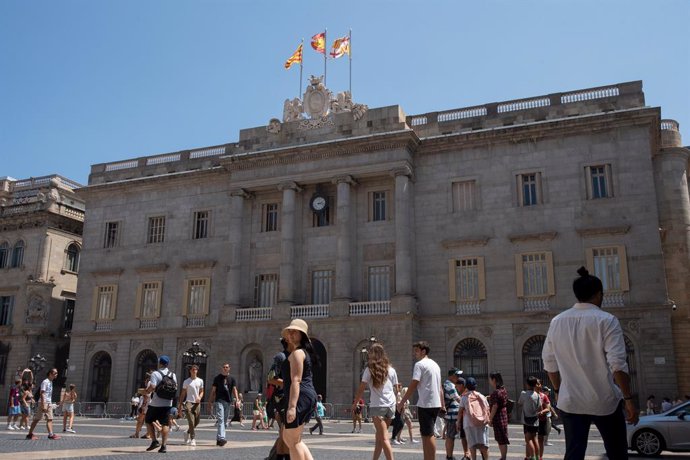 Archivo - Diverses persones caminen davant de l'edifici de l'Ajuntament de Barcelona