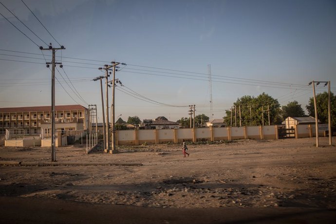Archivo - November 27, 2021, Maiduguri, Borno State, Nigeria: A resident walks under power lines in Maiduguri, the capital of Borno State..Islamic militant group Boko Haram, and more recently a faction called ISWAP, have been waging an insurgency in north