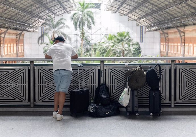 Un hombre con varias maletas en la estación de trenes Puerta de Atocha-Almudena Grandes, a 28 de junio de 2024