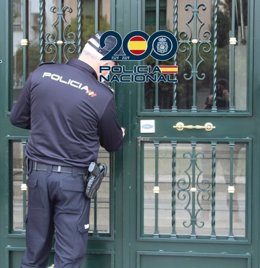Agente de la Policía Nacional en la puerta de un edificio.