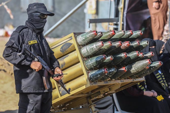 Archivo - 22 June 2023, Palestinian Territories, Khan Yunis: A masked fighter of the Al-Quds Brigades, the military wing of the Islamic Jihad Movement, stands next to a rocket launch pad during a military summer camp organized for local children, inside o