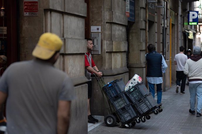 Archivo - Un repartidor con una carretilla, a 10 de mayo de 2023, en Barcelona, Catalunya (España). El número de parados registrados en las oficinas de los servicios públicos de empleo bajó en 73.890 personas en abril en relación al mes anterior (-2,6%) i