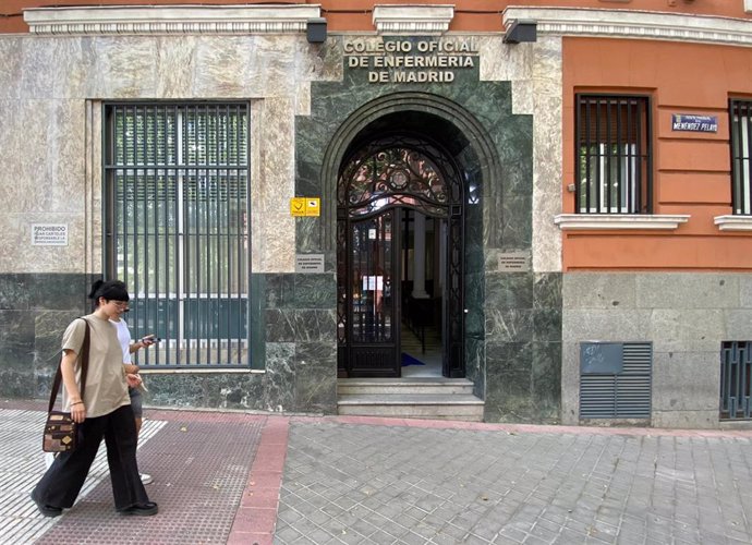 Archivo - Una mujer pasea por la sede del Colegio Oficial de Enfermería de Madrid, 