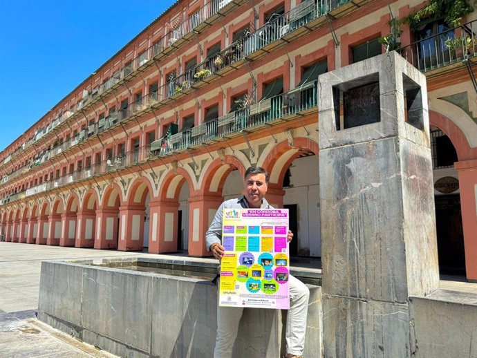 El delegado de Participación Ciudadana en el Ayuntamiento de Córdoba, Miguel Ruiz Madruga, con el cartel de actividades de 'En Córdoba, verano participa'.