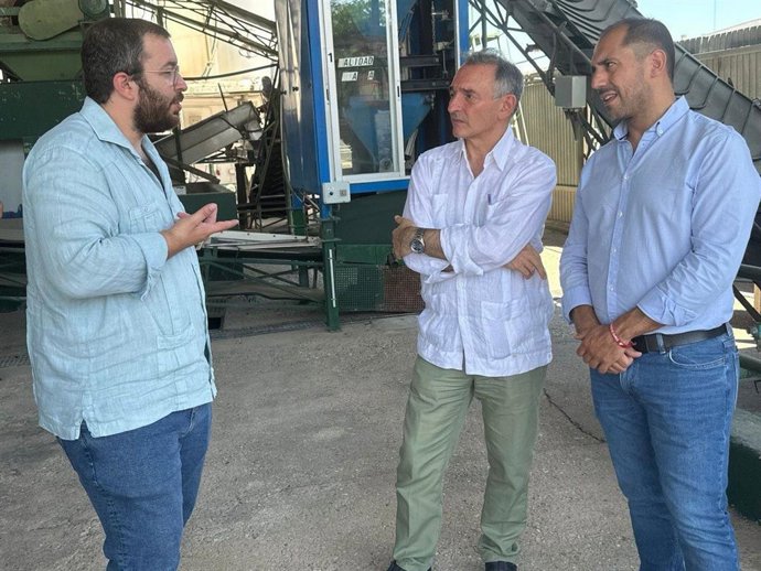 Santiago (centro), junto al coordinador de IU Córdoba, Sebastián Pérez (dcha.), en su visita a la Cooperativa Olivarera Germán Baena.