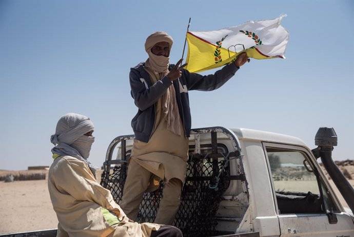 Archivo - November 13, 2019, Koygouma, Tombouctou (Timbuktu, Mali: A man proudly shows the flag of HCUA (High Council for the Unity of Azawad) and making the sign of -Victory- with the other hand during the visit of the UNHCR and MINUSMA accompanied by th