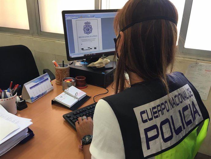 Agente de la Policía Nacional frente a un ordenador.