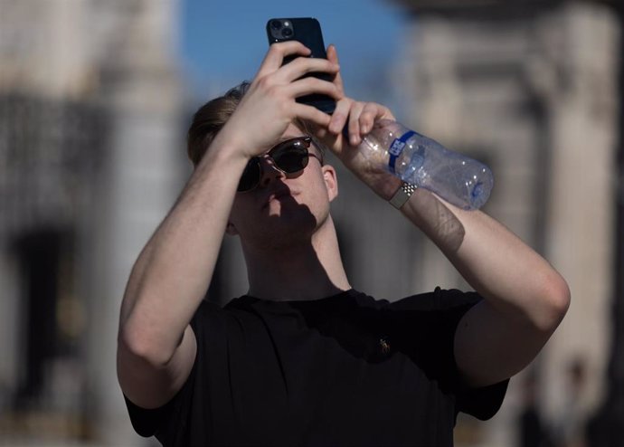 Archivo - Joven tomando una fotografía, en las inmediaciones del Palacio Real de Madrid, a 20 de febrero de 2024, en Madrid (España)