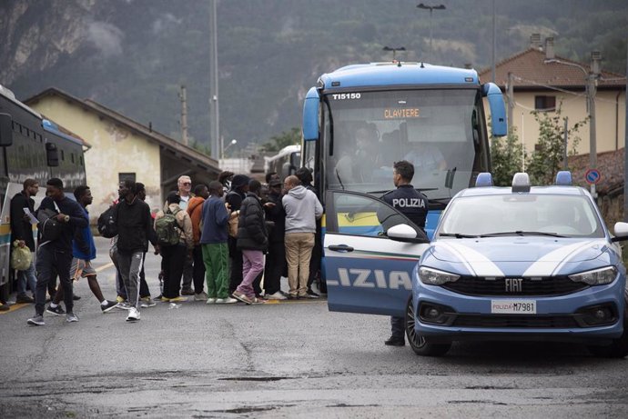 Archivo - Un grupo de migrantes sube a bordo de un autobús (imagen de archivo).