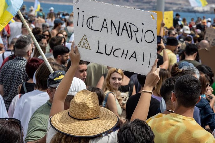 Archivo - Una persona sujeta un cartel de protesta durante una manifestación contra el modelo turístico, a 20 de abril de 2024, en Las Palmas de Gran Canaria, Gran Canaria, Canarias (España)
