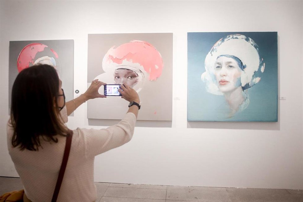 Archivo - Una mujer fotografía algunas de las piezas que componen la feria de arte contemporáneo Urvanity Art