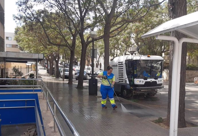 Una trabajadora de Emaya limpia una acera.