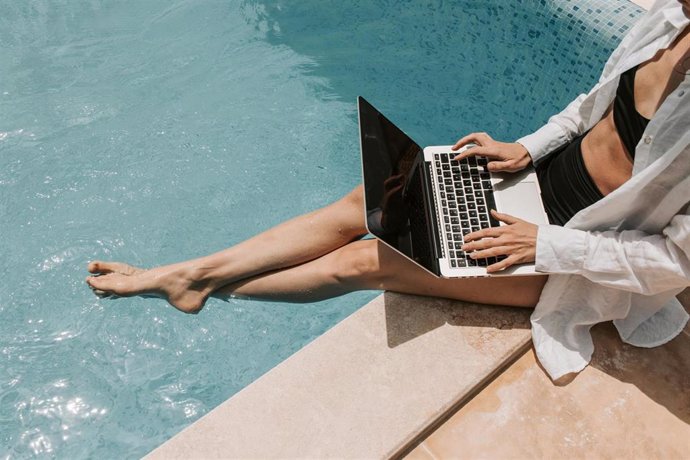Una chica en una piscina con un ordenador portátil