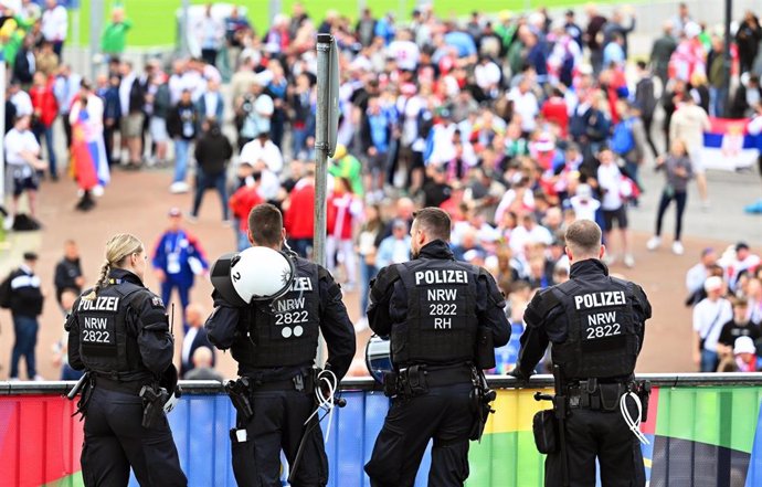 16 June 2024, North Rhine-Westphalia, Gelsenkirchen: Police officers stand in front of the stadium while the fans arrive for the UEFA EURO 2024 Group C soccer match between Serbia and England at Arena AufSchalke. Photo: Bernd Thissen/dpa