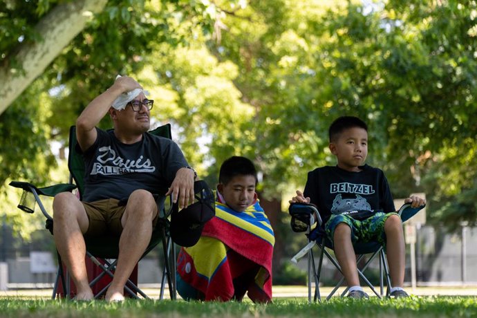 Archivo - June 30, 2023, Sacramento, California, USA: VAN TRAN sitting in the shade, wipes the sweat off his head in the 104 degree temperature with sons Levi, 11, and Gavin, 8, after a swim at Clunie Pool at McKinley Park Friday in Sacramento.