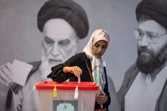 Una mujer introduce un voto en una urna en Teherán durante la segunda vuelta de las elecciones presidenciales en Irán