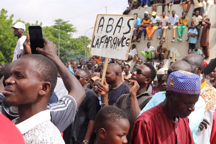 Archivo - Cartel que dice "A bas la France" (Abajo Francia) durante una protesta en apoyo de los golpistas en Niamey, la capital de Níger