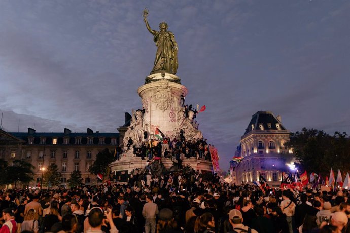 July 7, 2024, Paris, France, France: People gather in front of Le triomphe de la Republique statue during an election night event following the first results of the second round of France s legislative election at Republique Square in Paris. A broad left 