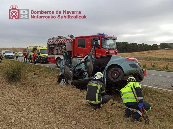 Efectivos de bomberos intervienen en el vehículo accidentado.