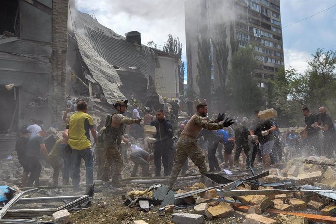 Trabajadores de los equipos de rescate buscan a víctimas entre los escombros de edificios alcanzados en la capital de Ucrania, Kiev, tras una oleada de bombardeos ejecutados por las Fuerzas Armadas de Rusia