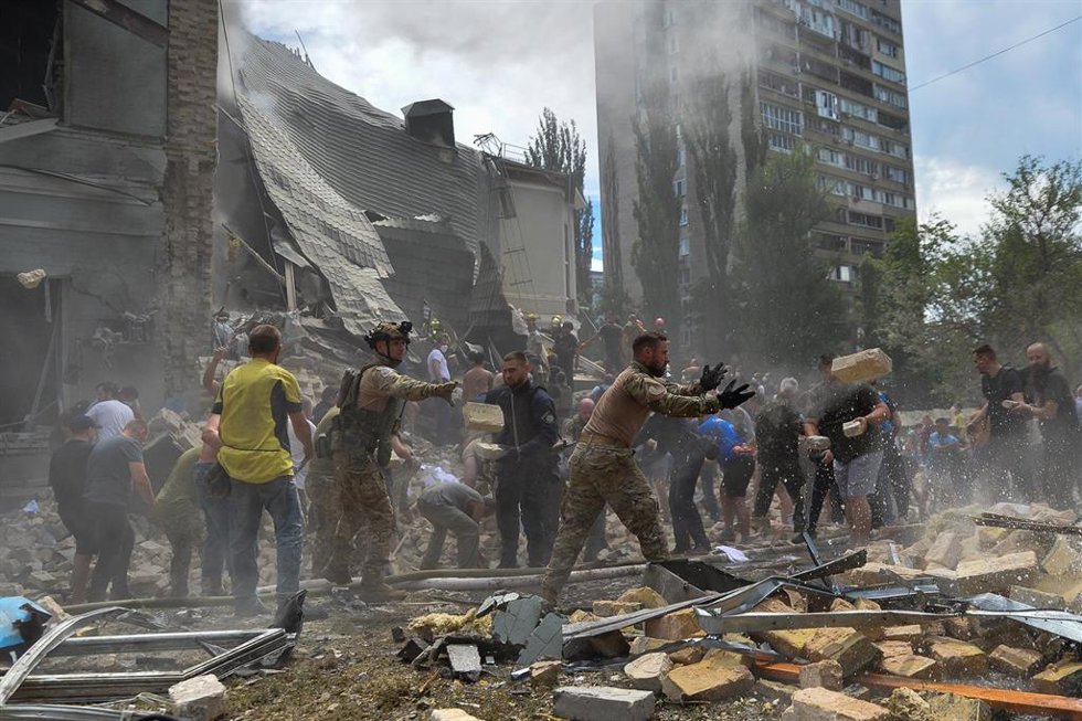 Trabajadores de los equipos de rescate buscan a víctimas entre los escombros de edificios alcanzados en la capital de Ucrania, Kiev, tras una oleada de bombardeos ejecutados por las Fuerzas Armadas de Rusia