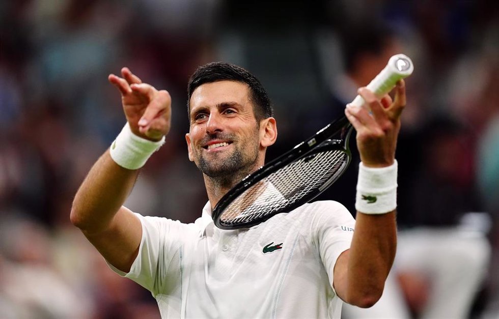 Serbian tennis player Novak Djokovic pretends to play a violin after beating Denmark's Holger Rune during their men's singles round of 16 tennis match on day eight of the 2024 Wimbledon Championships at the All England Lawn Tennis and Croquet Club, Lond