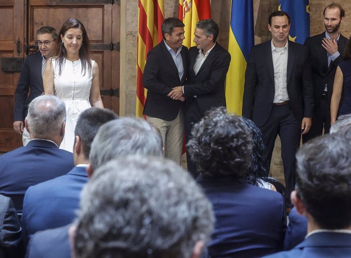 El president de la Generalitat Valenciana, Carlos Mazón (3i), y el CFO de Poweco Spain, Javier Rivera (3d), se sludan durante la firma del convenio de colaboración entre la Generalitat y PowerCo, en el Palau de la Generalitat, a 9 de julio de 2024. 