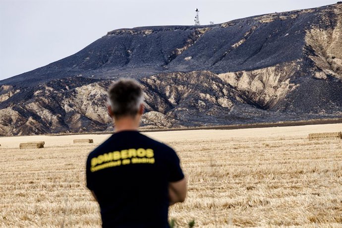 Un bomber treballa en la zona cremada durant un incendi forestal,  a 26 de juny de 2024, a Alcalá de Henares, Madrid (Espanya).  