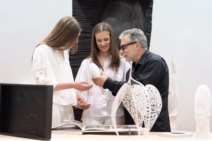 La Princesa Leonor (c) y la Infanta Sofía (i) escuchan al escultor Juame Plensa (d) durante una visita a su taller, a 9 de julio de 2024, en Sant Feliu de Llobregat (Barcelona)