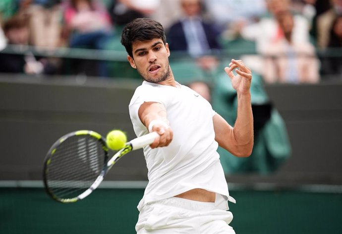 09 July 2024, United Kingdom, London: Spanish tennis player Carlos Alcaraz plays a forehand return to US Tommy Paul during their men's singles Quarter-final tennis match on day nine of the 2024 Wimbledon Championships at the All England Lawn Tennis and Cr