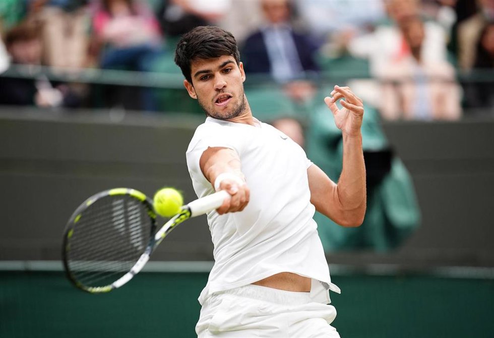 09 July 2024, United Kingdom, London: Spanish tennis player Carlos Alcaraz plays a forehand return to US Tommy Paul during their men's singles Quarter-final tennis match on day nine of the 2024 Wimbledon Championships at the All England Lawn Tennis and 