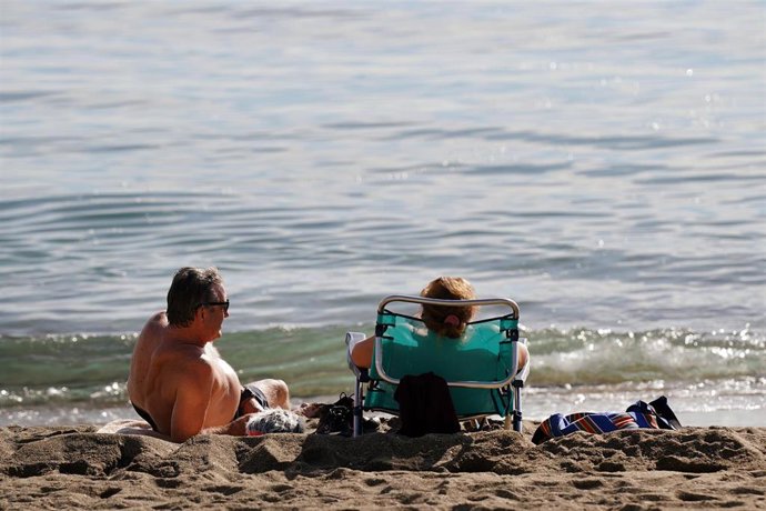 Archivo - Varias personas disfrutan tomando el sol en la playa de la Malagueta, a 12 de diciembre de 2023 en Málaga, Andalucía.