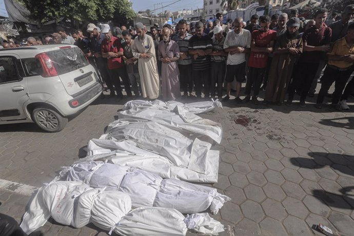 Palestinos frente a varios muertos a causa de la ofensiva de Israel contra la Franja de Gaza tras su traslado al Hospital Mártires de Al Aqsa de Deir al Balá (archivo)