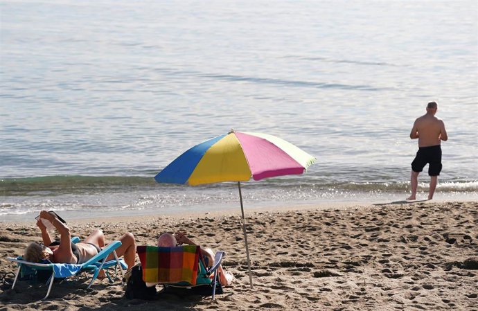 Archivo - Varias personas disfrutan tomando el sol en la playa de la Malagueta, a 12 de diciembre de 2023 en Málaga, Andalucía.