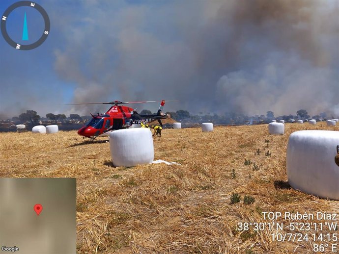 Uno de los helicópteros que interviene en el operativo desplegado en la lucha contra el incendio declarado en Valsequillo, que se ve al fondo.