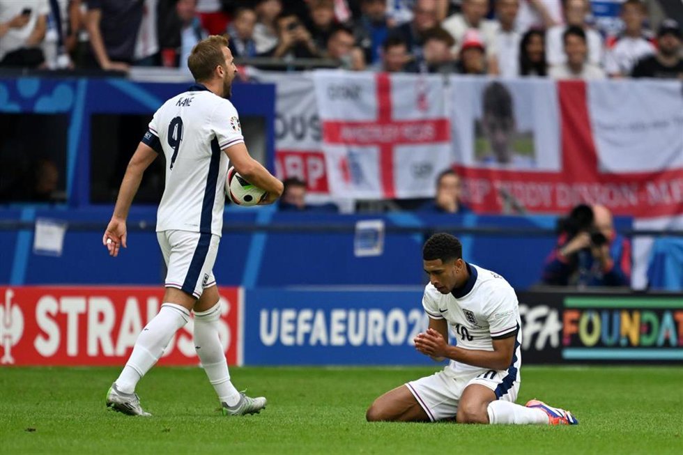 30 June 2024, North Rhine-Westphalia, Gelsenkirchen: England's Harry Kane (L) and England's Jude Bellingham on the pitch during the UEFAEURO2024 round of 16 soccer match between England and Slovakia at the Schalke Arena. Photo: Bernd Thissen/dpa