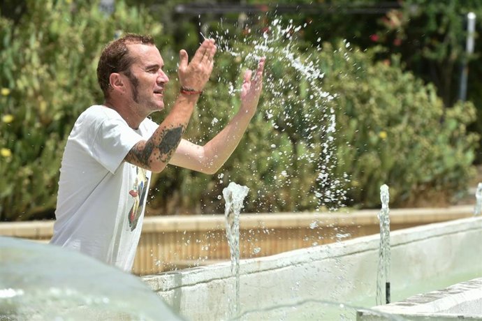 Archivo - Un hombre se refresca en una fuente del centro de Murcia durante la ola de calor 