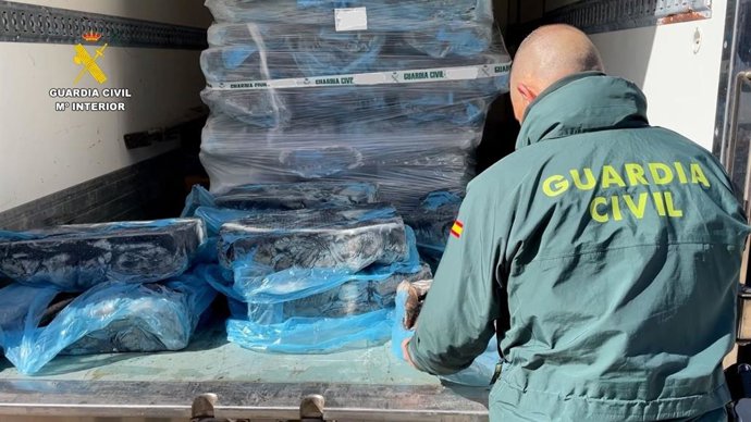 Agente de la Guardia Civil con la mercancía de pulpo recuperada.