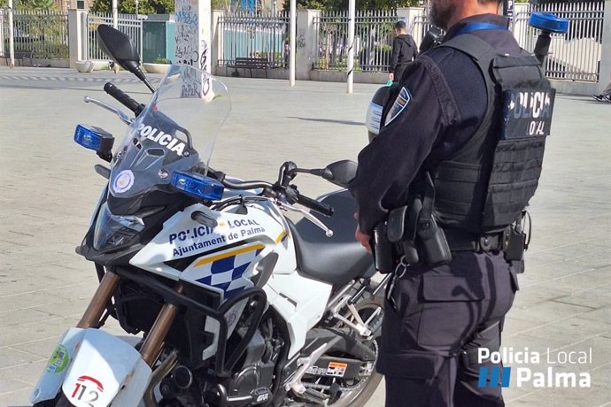 Un agente de la Policía Local de Palma junto a una motocicleta.
