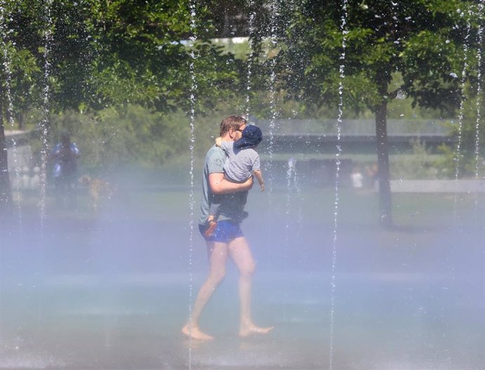 Archivo - Un hombre con su hijo pasa por los chorros de agua de la playa de Madrid Río, a 24 de mayo de 2024, en Madrid (España). Durante la visita, el alcalde ha comprobado cómo se activa esta instalación para combatir la llegada del calor.