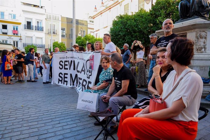 Concentración vecinal en la plaza del Salvador, a la que asistió la portavoz del grupo municipal Con Podemos-IU, que aparece tras la pancarta.